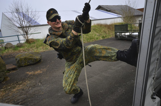 Kräftig ziehen: Ein Soldat beim Zeltaufbau in Engelrod.