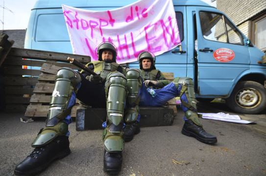 Warten auf die Schlacht: Zwei Soldaten, die ihre Kameraden gleich als Demonstranten attackieren werden, sitzen vor einer Straßensperre.  