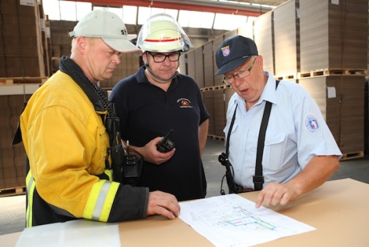 Lagebesprechung zwischen Pappkartons: Werkfeuerwehrleiter Björn Preuß von Brincken mit den Stadtbrandinspektoren Jürgen Eifert und Hans-Jürgen Schütz