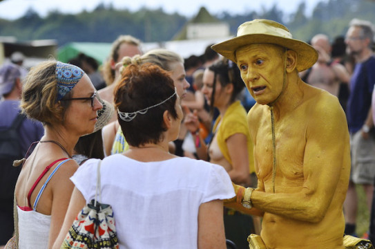 Gefragter Gesprächspartner: Der "Goldene Mann" im Gespräch mit zwei Festival-Besucherinnen, die ihn in seiner Aktion unterstützen. 