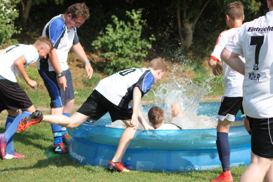 Kleine Abkühlung tut gut: Spieler erfrischen sich in einem Planschbecken beim Turnier.