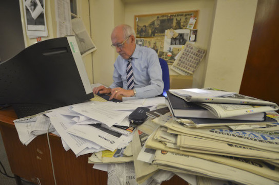 Kreatives Chaos: John Balment an seinem Schreibtisch im Mid-Devon Advertiser. Hinter ihm an der Pinnwand hängt eine Doppelseite der Pferderenn-Zeitung Racing Post. 