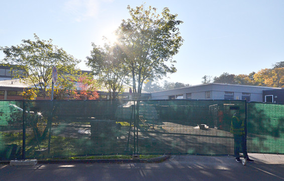Abgesperrt: Der Eingang der Alsfelder Großsporthalle hinter einem grünen Sichtschutz. Ein Wachmann steht bei dem Tor. 