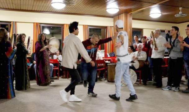 Ausgelassenes Tänzchen: junge Flüchtlinge bewegen sich zu der Musik bei ihrem Abschiedsfest. 