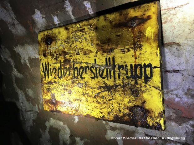 Halb verrostet: Ein Schild mit der Aufschrift "Wiederherstelltrupp" in einem alten Luftschutzstollen einer Fabrik.