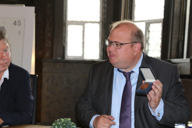 Bürgermeister Stephan Paule freut sich den Erfindern die Medaille überreichen zu können. Foto: ls