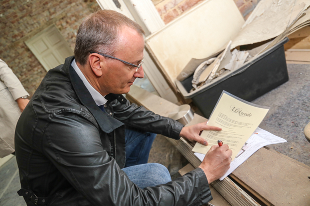 Ralf Bohn unterschreibt die Urkunde, die mit in die Zeitkapsel gesteckt wird. 