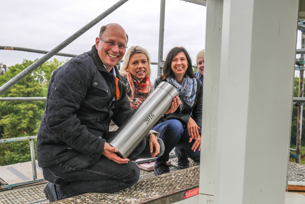 Architekt Jochen Weppler, Bauherrin Tanja Bohn, Statikerin Maike Jungermann und Bauzeichnerin Katharina Runkel am Fuße der Turmspitze. Hier soll die Zeitkapsel ihren Platz finden. (v.l.n.r.)