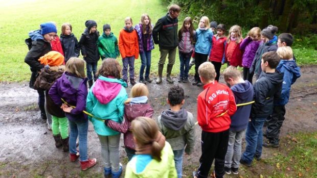 Kidner stehen auf einem Waldweg im Kreis