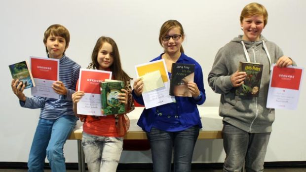Kidner stehen mit Urkunden nebeneinander