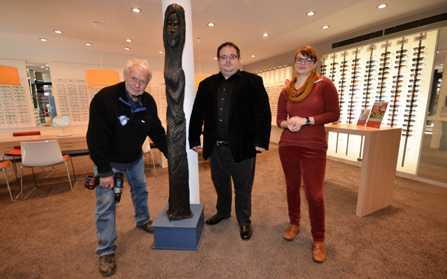 Foto beim Aufbau: Der Künstler Dr. Siegfried Modra verteilt gerade seine Holzskulpturen in der Stadt. Mit ihm auf dem Bild sind Uwe Eifert von der Stadtverwaltung und Janine Kristen vom Optiker Neusehland. Fotos: jal